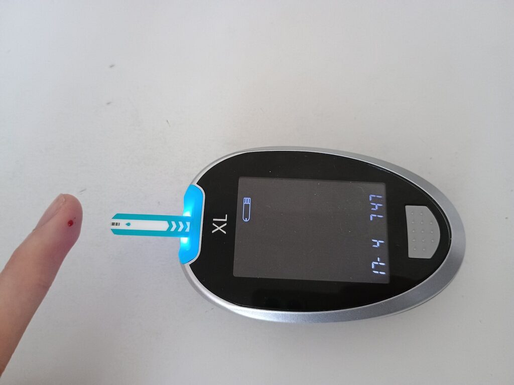 A close-up of a blood glucose meter showing a reading