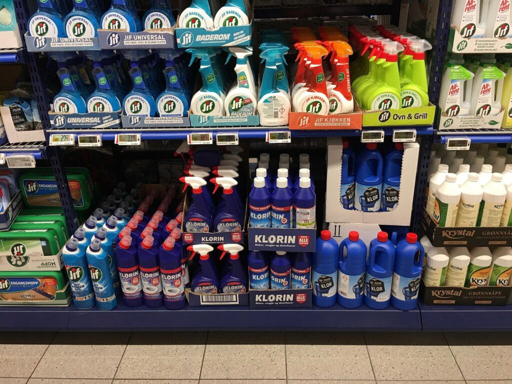 A shopper facing long supermarket shelves of products