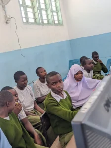 Students gathered around computers in a school computer lab.