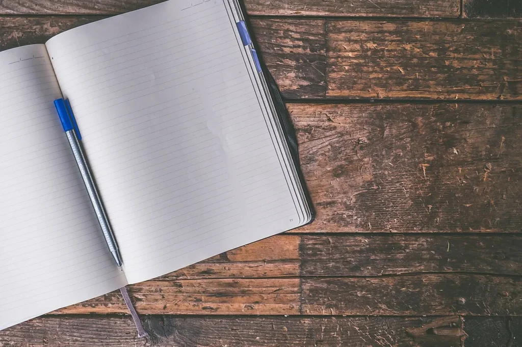 An open journal and pen on a desk, ready for writing.