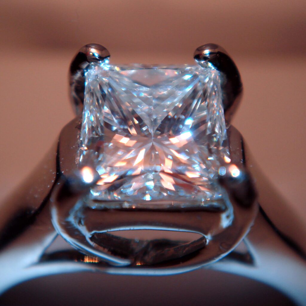 A brilliant cut diamond held in jeweller's tweezers